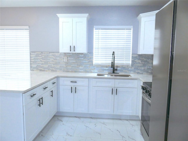 1302 Highview Rd, Brandon, FL 33510 - kitchen featuring stove, a peninsula, light marble finish flooring, and white cabinetry