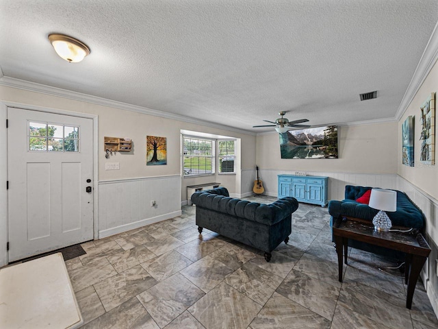 2937 Eagles Nest Rd, Fruitland Park, FL 34731 - living area featuring wainscoting, a textured ceiling, crown molding, and ceiling fan