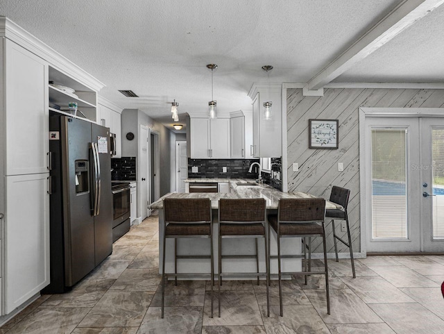 2937 Eagles Nest Rd, Fruitland Park, FL 34731 - kitchen with a peninsula, stainless steel appliances, tasteful backsplash, a textured ceiling, and french doors