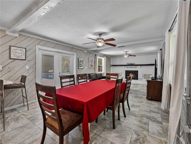 2937 Eagles Nest Rd, Fruitland Park, FL 34731 - dining room featuring a ceiling fan, french doors, wood walls, a textured ceiling, and a fireplace