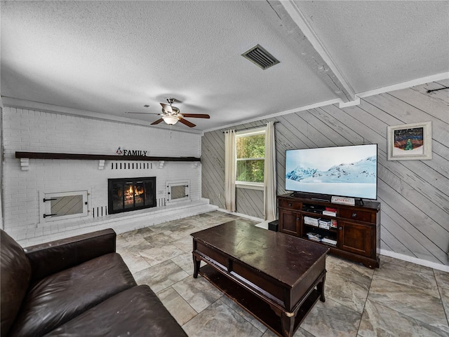 2937 Eagles Nest Rd, Fruitland Park, FL 34731 - living room with a ceiling fan, a textured ceiling, a large fireplace, and wood walls