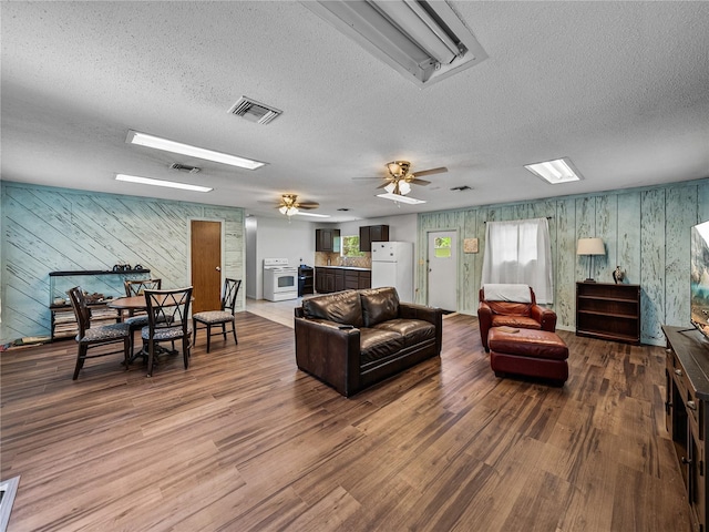 2937 Eagles Nest Rd, Fruitland Park, FL 34731 - living area with a textured ceiling, wood finished floors, wooden walls, and a ceiling fan