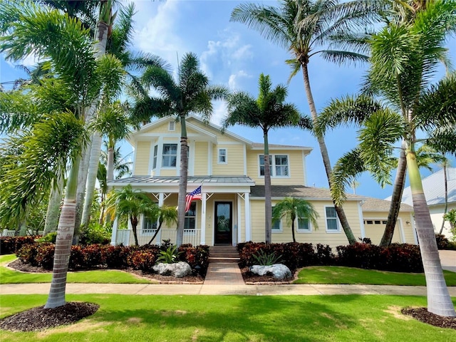 703 Islebay Dr, Apollo Beach, FL 33572 - view of front of property with covered porch, a front lawn, driveway, and a standing seam roof