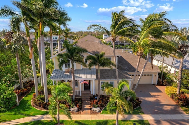 703 Islebay Dr, Apollo Beach, FL 33572 - view of front of house featuring driveway, an attached garage, roof with shingles, a porch, and stucco siding