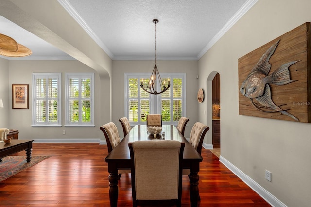 703 Islebay Dr, Apollo Beach, FL 33572 - dining area featuring a chandelier, arched walkways, dark wood-style flooring, ornamental molding, and a textured ceiling