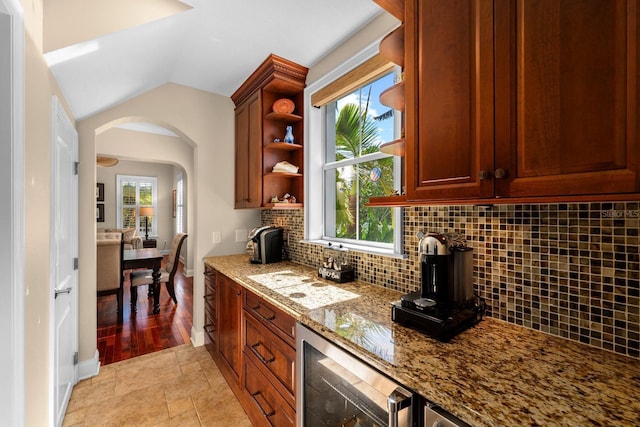 703 Islebay Dr, Apollo Beach, FL 33572 - kitchen featuring wine cooler, open shelves, vaulted ceiling, arched walkways, and backsplash