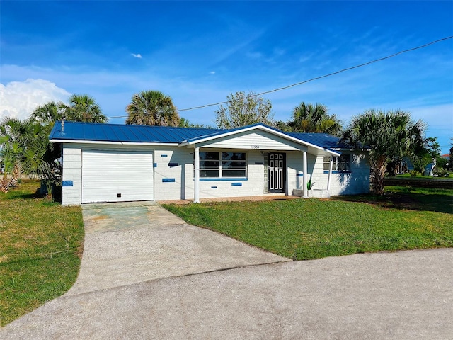 13534 Evelane Dr, Hudson, FL 34667 - ranch-style home with driveway, an attached garage, a front lawn, a metal roof, and concrete block siding