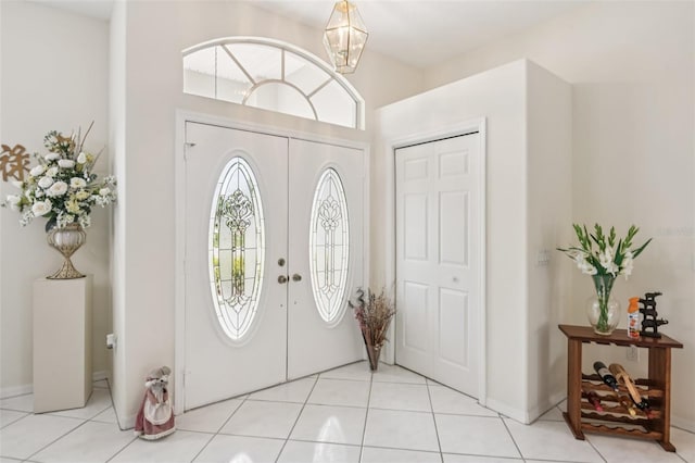 8704 Cypress Lakes Blvd, New Port Richey, FL 34653 - foyer entrance with light tile patterned floors and a chandelier