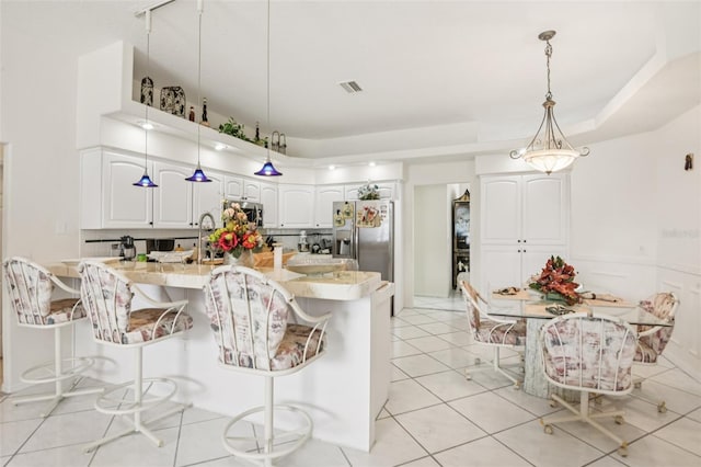 8704 Cypress Lakes Blvd, New Port Richey, FL 34653 - kitchen featuring a kitchen breakfast bar, white cabinetry, appliances with stainless steel finishes, and light countertops