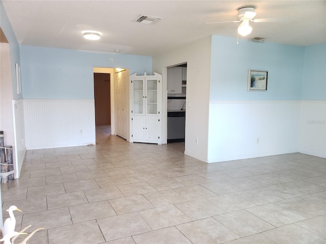 2227 Grenadier Dr Unit 140, Sun City Center, FL 33573 - unfurnished room featuring wainscoting, ceiling fan, light tile patterned floors, and arched walkways
