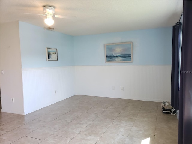 2227 Grenadier Dr Unit 140, Sun City Center, FL 33573 - empty room with a wainscoted wall, ceiling fan, and light tile patterned flooring