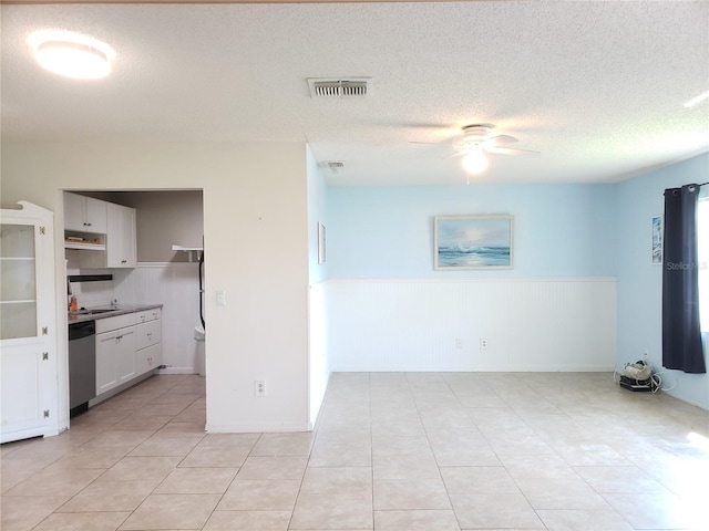 2227 Grenadier Dr Unit 140, Sun City Center, FL 33573 - empty room with ceiling fan, wainscoting, a textured ceiling, and light tile patterned floors