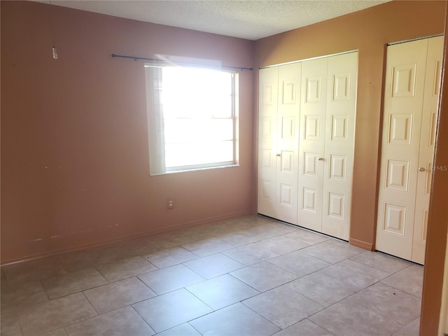 2227 Grenadier Dr Unit 140, Sun City Center, FL 33573 - unfurnished bedroom with a closet, a textured ceiling, and light tile patterned flooring