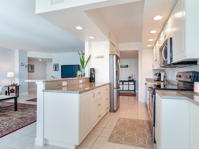 660 Island Way Unit 703, Clearwater Beach, FL 33767 - kitchen featuring stainless steel appliances, light tile patterned flooring, recessed lighting, tasteful backsplash, and white cabinets
