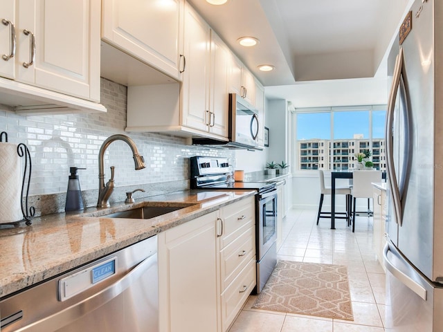 660 Island Way Unit 703, Clearwater Beach, FL 33767 - kitchen featuring stainless steel appliances, light tile patterned flooring, tasteful backsplash, light stone counters, and recessed lighting