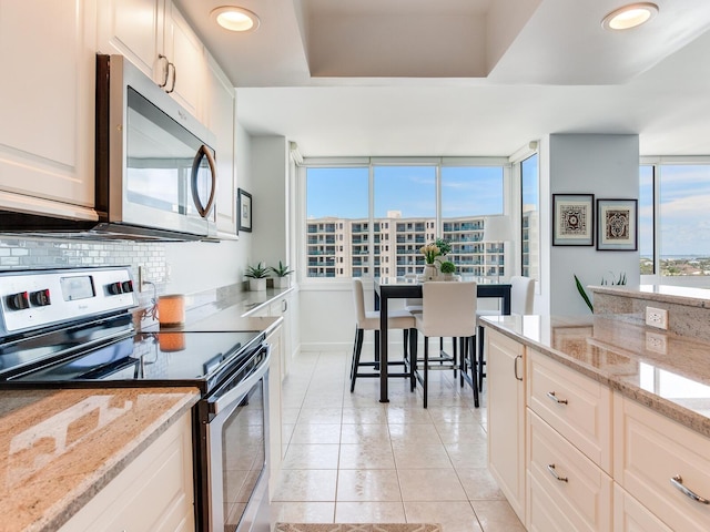 660 Island Way Unit 703, Clearwater Beach, FL 33767 - kitchen featuring appliances with stainless steel finishes, backsplash, light stone counters, light tile patterned flooring, and recessed lighting