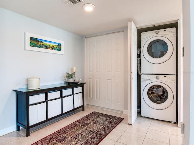 660 Island Way Unit 703, Clearwater Beach, FL 33767 - washroom featuring stacked washing machine and dryer and light tile patterned floors