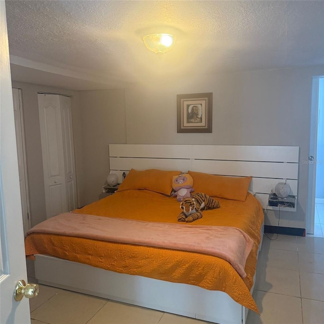10004 Ethel St, Gibsonton, FL 33534 - bedroom with light tile patterned flooring and a textured ceiling