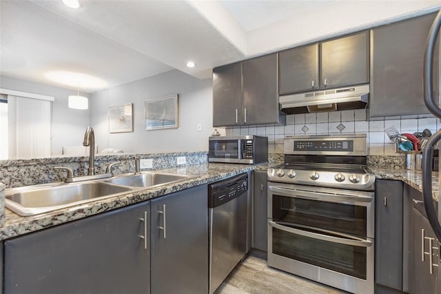 4905 25th St W Unit 101, Bradenton, FL 34207 - kitchen with appliances with stainless steel finishes, under cabinet range hood, backsplash, light wood-style flooring, and recessed lighting