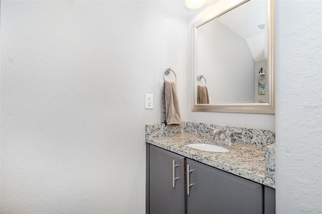 4905 25th St W Unit 101, Bradenton, FL 34207 - bathroom with vanity, lofted ceiling, and a textured wall