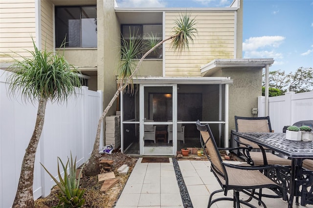 4905 25th St W Unit 101, Bradenton, FL 34207 - back of property with a sunroom, outdoor dining area, and stucco siding