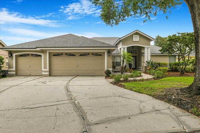 816 Sandringham Ln, Lutz, FL 33549 - view of front of property featuring driveway, stucco siding, a garage, and a shingled roof