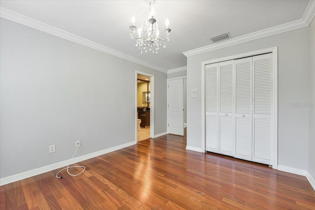 816 Sandringham Ln, Lutz, FL 33549 - unfurnished bedroom with a chandelier, wood finished floors, ornamental molding, and a closet