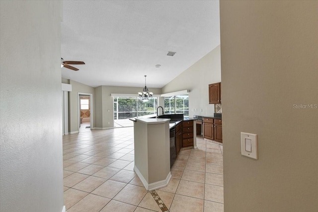 816 Sandringham Ln, Lutz, FL 33549 - kitchen with lofted ceiling, light tile patterned floors, an island with sink, a ceiling fan, and a chandelier