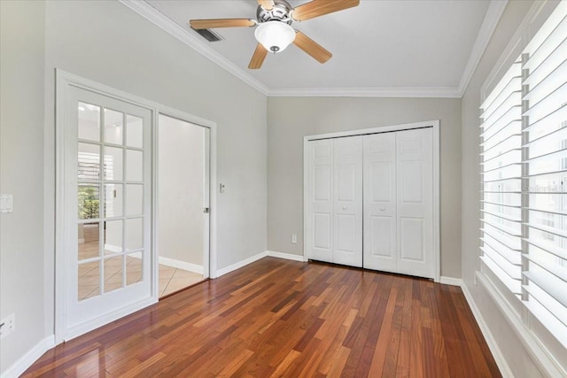 816 Sandringham Ln, Lutz, FL 33549 - unfurnished bedroom with dark wood-style floors, multiple windows, ornamental molding, a ceiling fan, and a closet
