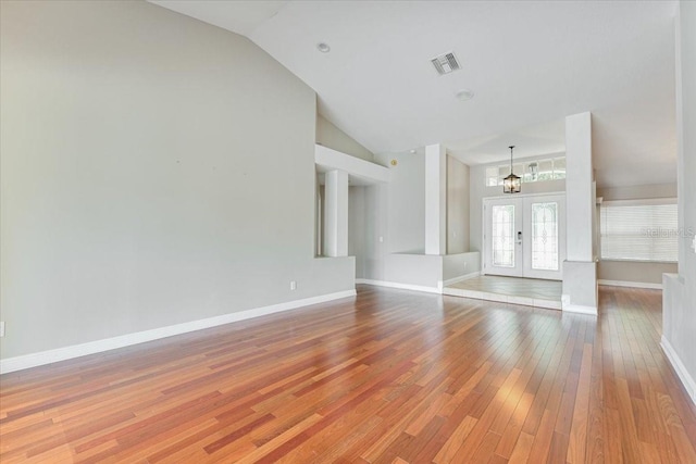 816 Sandringham Ln, Lutz, FL 33549 - unfurnished living room featuring a chandelier, wood-type flooring, french doors, and high vaulted ceiling