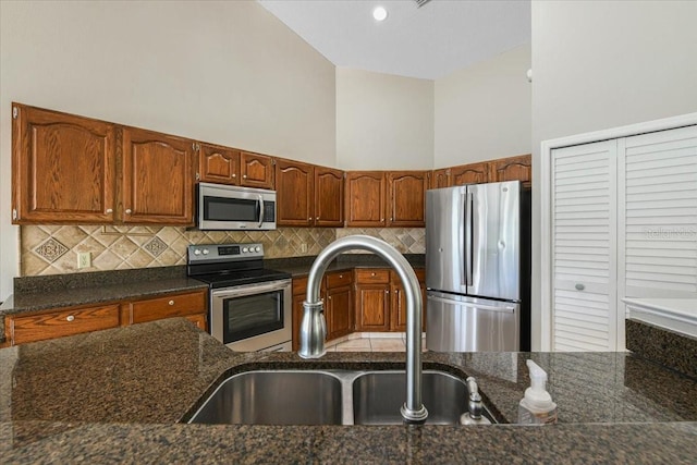 816 Sandringham Ln, Lutz, FL 33549 - kitchen featuring stainless steel appliances, tasteful backsplash, dark stone countertops, and brown cabinetry