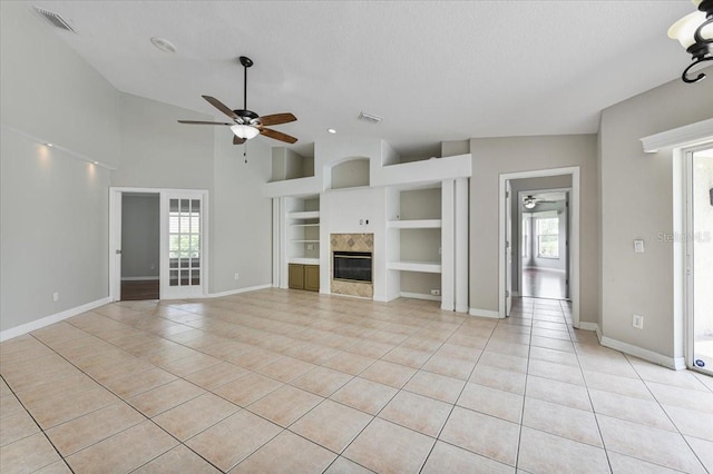 816 Sandringham Ln, Lutz, FL 33549 - unfurnished living room with built in features, ceiling fan, light tile patterned floors, vaulted ceiling, and healthy amount of natural light