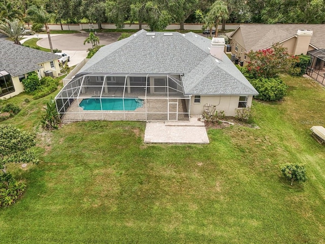 816 Sandringham Ln, Lutz, FL 33549 - back of property with a chimney, a patio area, an outdoor pool, a shingled roof, and a lawn