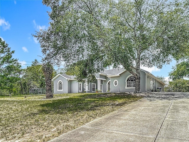 8303 Nightwalker Rd, Weeki Wachee, FL 34613 - single story home with stucco siding, driveway, and a front yard