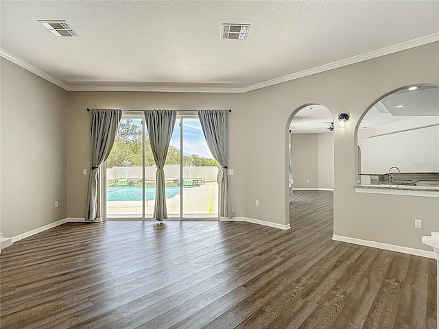 8303 Nightwalker Rd, Weeki Wachee, FL 34613 - spare room featuring ornamental molding, dark wood-type flooring, arched walkways, and a textured ceiling