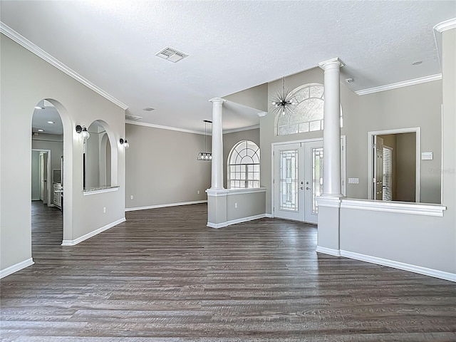 8303 Nightwalker Rd, Weeki Wachee, FL 34613 - entrance foyer with dark wood-style floors, crown molding, ornate columns, french doors, and a textured ceiling