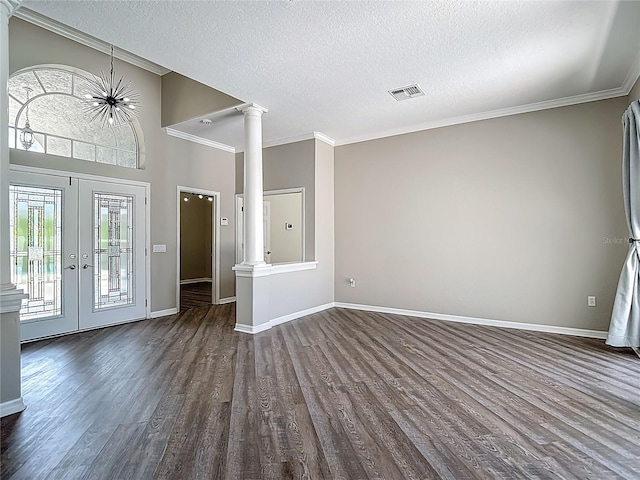 8303 Nightwalker Rd, Weeki Wachee, FL 34613 - foyer with ornate columns, dark wood-style floors, french doors, crown molding, and a textured ceiling