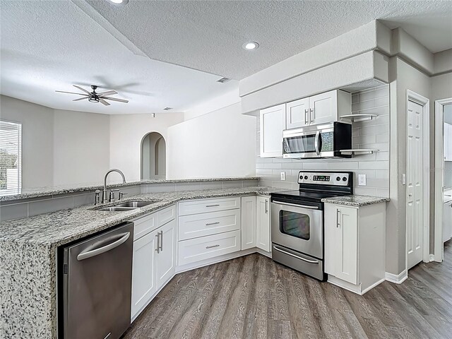8303 Nightwalker Rd, Weeki Wachee, FL 34613 - kitchen featuring stainless steel appliances, open shelves, a textured ceiling, dark wood-style floors, and a ceiling fan