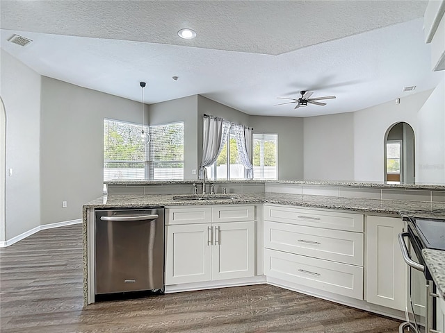 8303 Nightwalker Rd, Weeki Wachee, FL 34613 - kitchen featuring stainless steel dishwasher, arched walkways, dark wood-style flooring, stove, and white cabinetry