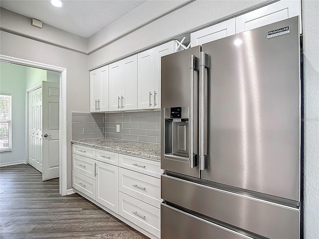 8303 Nightwalker Rd, Weeki Wachee, FL 34613 - kitchen with high end refrigerator, white cabinets, dark wood finished floors, tasteful backsplash, and light stone counters