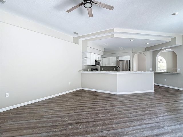 8303 Nightwalker Rd, Weeki Wachee, FL 34613 - kitchen with stainless steel appliances, dark wood-style flooring, a ceiling fan, white cabinets, and light countertops