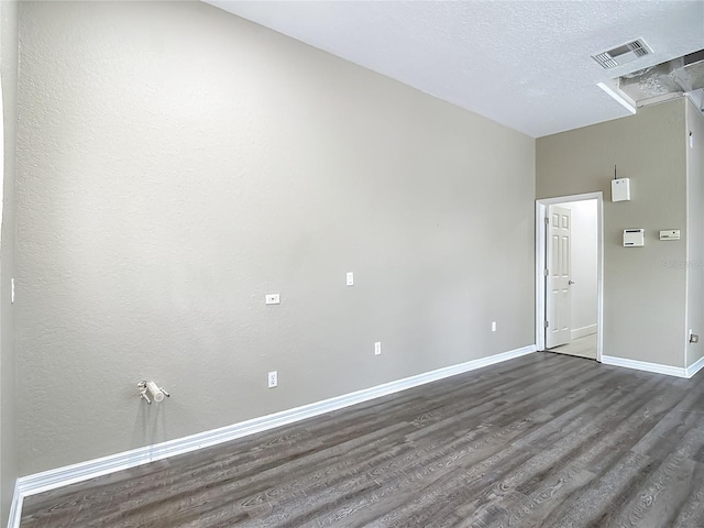 8303 Nightwalker Rd, Weeki Wachee, FL 34613 - empty room with dark wood finished floors and a textured ceiling