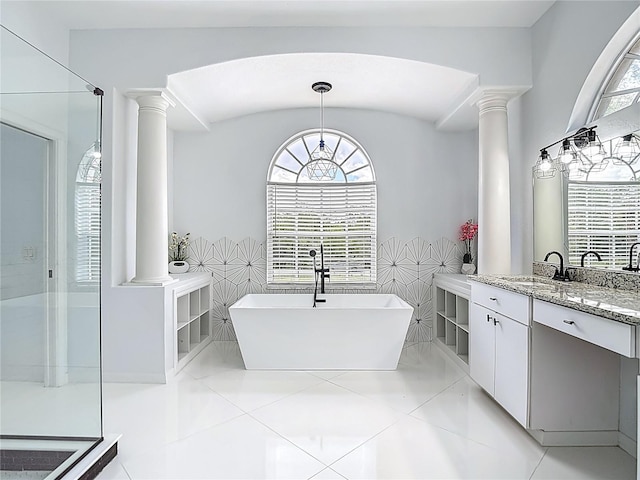 8303 Nightwalker Rd, Weeki Wachee, FL 34613 - bathroom with ornate columns, a soaking tub, vanity, and tile patterned floors