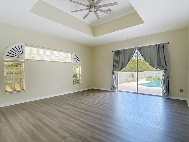 8303 Nightwalker Rd, Weeki Wachee, FL 34613 - empty room with a raised ceiling, a ceiling fan, and wood finished floors