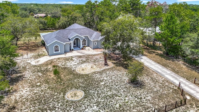8303 Nightwalker Rd, Weeki Wachee, FL 34613 - view of front of home with stucco siding and a forest view