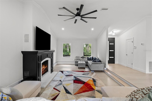 900 Oak Hollow Pl, Brandon, FL 33510 - living area with crown molding, light wood-type flooring, a warm lit fireplace, a ceiling fan, and recessed lighting
