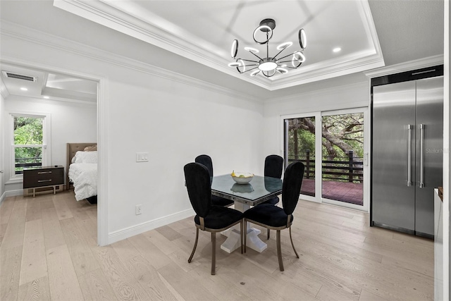 900 Oak Hollow Pl, Brandon, FL 33510 - dining room with a tray ceiling, light wood-style flooring, a chandelier, and ornamental molding