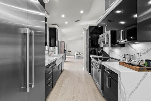 900 Oak Hollow Pl, Brandon, FL 33510 - kitchen featuring high end appliances, dark cabinets, light wood-type flooring, modern cabinets, and recessed lighting