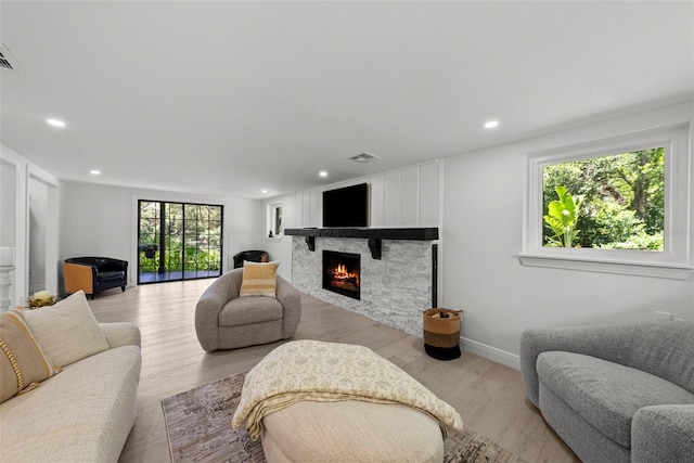 900 Oak Hollow Pl, Brandon, FL 33510 - living room featuring a lit fireplace, recessed lighting, and light wood-type flooring