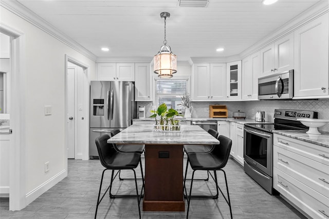 900 Oak Hollow Pl, Brandon, FL 33510 - kitchen featuring appliances with stainless steel finishes, a breakfast bar, white cabinets, recessed lighting, and a kitchen island